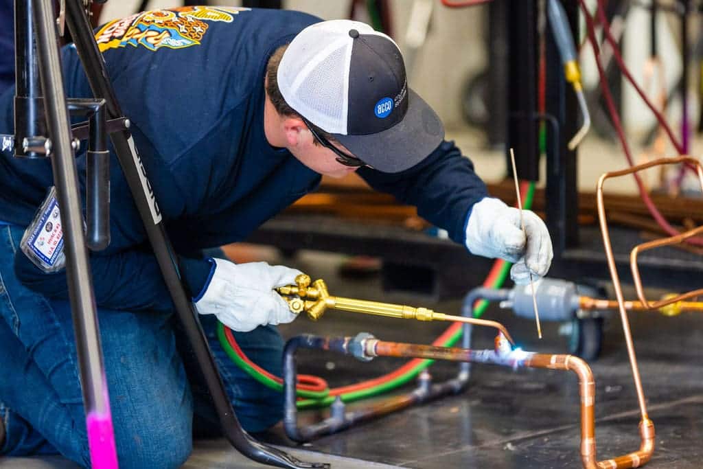 A technician soldering copper pipe